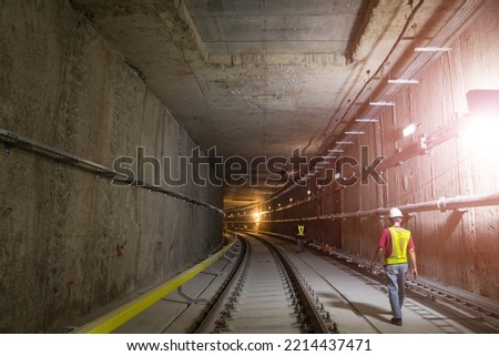 Soft focus of tunnel. Engineers wear helmet, vests safety .Technician control underground construction at working shaft to maintenance. Transport pipeline by Tunnel Boring Machine method for train.