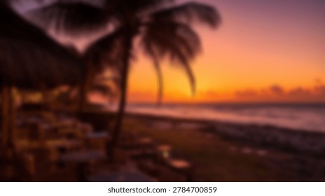 A soft focus view of a beachside dining area with palm trees silhouetted against a vibrant orange and purple sunset sky