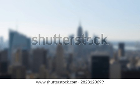 A soft focus view of a dense urban skyline with numerous skyscrapers reaching towards the sky.