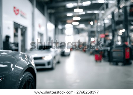 A soft focus view inside a busy automotive service center, showing multiple cars lined up for maintenance and various tools and machinery in the background, conveying a sense of activity and professi.