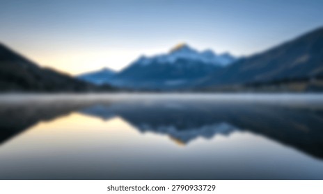 A soft focus view of a mountain range reflecting in a still lake during the golden hour of sunrise in a peaceful natural environment.