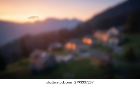 A soft focus view of a small mountain village with glowing house lights nestled in a valley at dusk under a sunset sky
