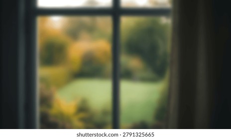 A soft focus view through a window pane showing a blurred green lawn and yellow autumn trees in a residential garden setting