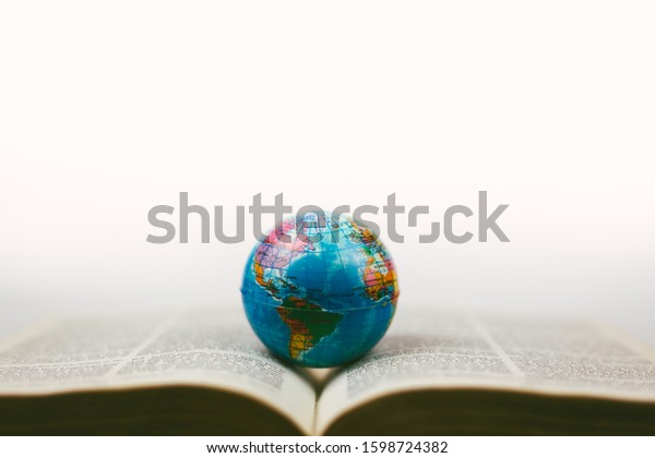 soft focus vintage globe with open\
Bible and magnifying glass, a missions\
concept.