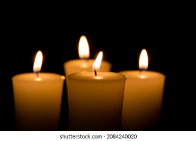 Soft focus of white candles burning, isolated on black background. Concept of religion, death, memoriam, and peace - Shutterstock ID 2084240020