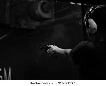 Soft Of Focus. Woman Pointing Gun At Target On Dark Background, Front Gun Focus, Vintage Tone