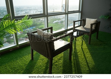 Soft focus of woven wicker seamless pattern table and chairs is basketwork by weaving plastic on the green grass near the glass window with sunlight to shine at the living room.