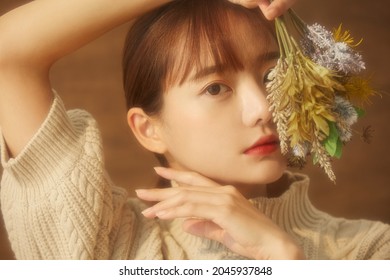 Soft focused portrait of a young Asian woman with flowers - Powered by Shutterstock