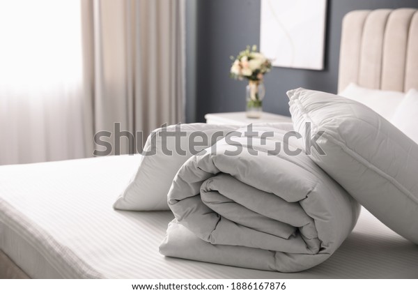 Soft folded\
blanket and pillows on bed\
indoors