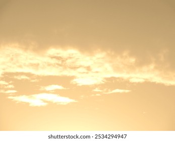 Soft golden clouds at sunset, casting a warm glow across the sky, offering a moment of tranquility.