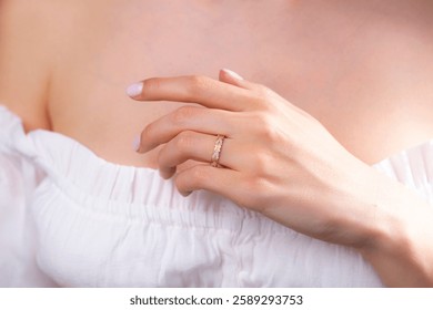 A soft image of a model and a gold ring on her finger