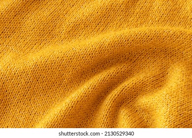 Soft Knitted Yellow Sweater Texture Closeup. Light Orange Abstract Background. Trendy Soft Mustard-colored Backdrop For Web Design. Luxury Twisted Fabric Backplate 