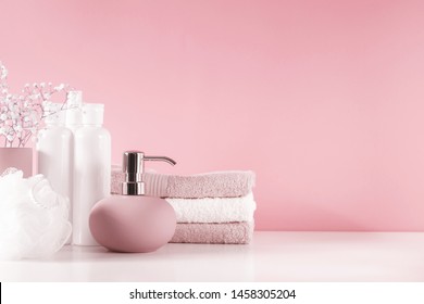 Soft Light Bathroom Decor In Pastel Pink Color, Towel, Soap Dispenser, White Flowers, Accessories On Pastel Pink Shelf. Elegant Decor Bathroom Interior.