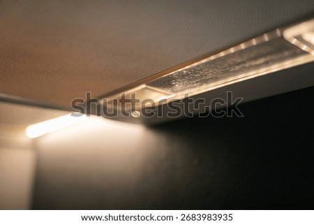 Soft light emanating from range hood in dark kitchen