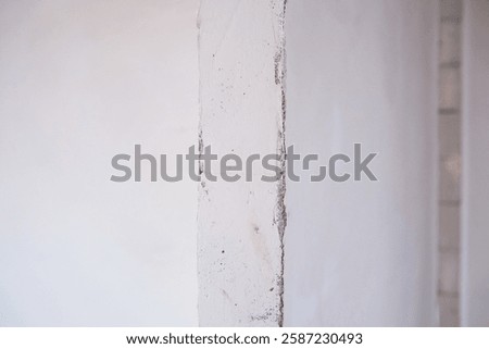 Soft light enhances the texture of a plaster wall corner in a minimalist space.