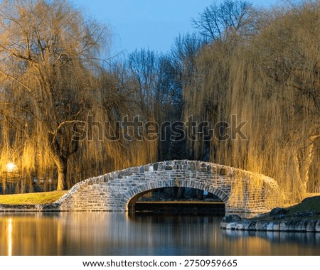 Soft light settles over the stone bridge as willow branches glow against the evening sky, their reflections drifting across the calm water. Upper Onondaga Park becomes a quiet stop for travelers, a peaceful moment where Syracuse reveals its most timeless charm
