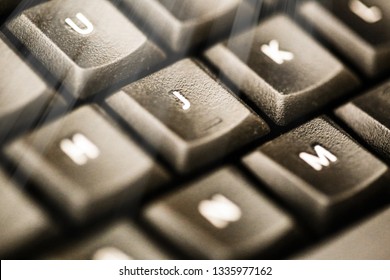 Soft light or sun rays on a close up computer keys with letters from a pc keyboard in macro style. Suitable as a background wallpaper or texture