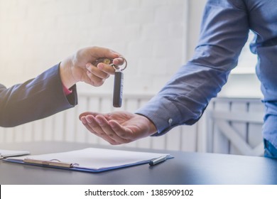Soft Light,A young businessman has entered into a new car lease agreement in the office of the car dealer and accepts the car keys after completing the contract
Concept of contract for car purchase