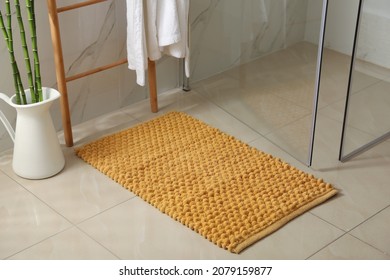 Soft orange bath mat on floor indoors