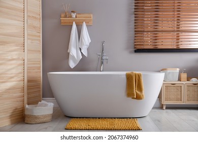 Soft orange mat on floor near tub in bathroom. Interior design - Shutterstock ID 2067374960