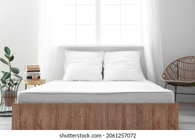 Soft orthopedic mattress on bed in room