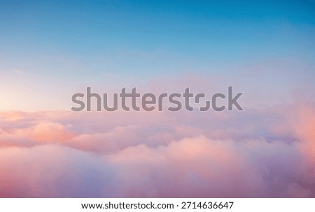 Soft pastel clouds drift softly across the bright morning sky, creating a breathtaking scene of tranquility. Sky is painted in soft shades of pink and orange. Photo wallpaper. Beauty of earth.