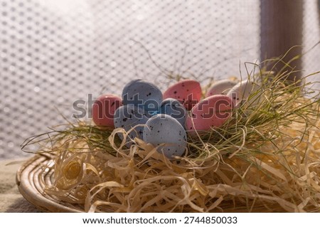 Soft pastel eggs in straw creating natural spring background texture