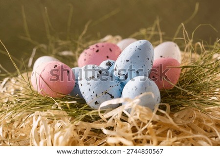 Soft pastel eggs in straw creating natural spring background texture
