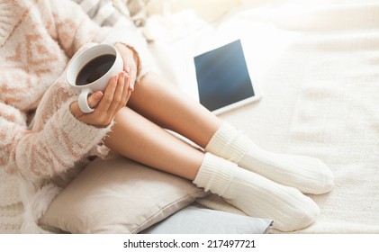 Soft photo of woman on the bed with tablet and cup of coffee in hands, top view point - Powered by Shutterstock