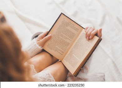 Soft photo of woman on the bed with old book and cup of coffee, top view point