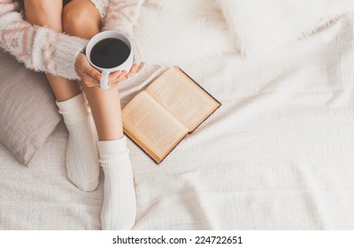 Soft Photo Of Woman On The Bed With Old Book And Cup Of Coffee In Hands, Top View Point. Cozy, Comfy, Soft