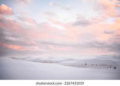 Soft pink clouds at sunset over white sand dunes in White Sands National Park, New Mexico. 