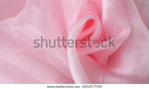 Soft pink color organdy or organza fabric\
texture with beautiful and closeup detail. Luxury textile pattern\
with soft and delicate\
material.