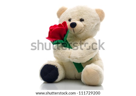 Soft plush teddy bear toy clutching a single red rose in its arms for an anniversary or Valentines celebration