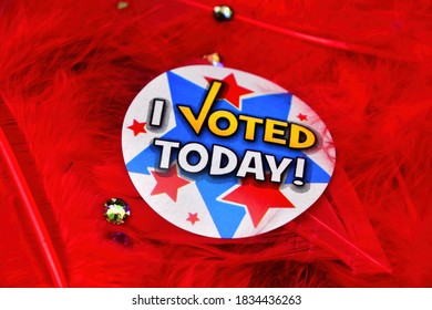 Soft Red Feather With A I Voted Today Sticker And Glass Jewelry With Soft Blurr Background.
 Vote Election Concept