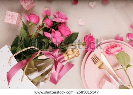 A soft and romantic dinner setup featuring pink plates, golden cutlery, a champagne glass, fresh roses, and heart decorations.