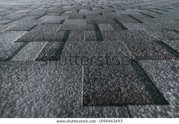 Soft roof tiled gray grainy texture on\
the top of a summer house lit by the sun; grey soft roofing tiles\
covering a building, focus on the middle\
distance
