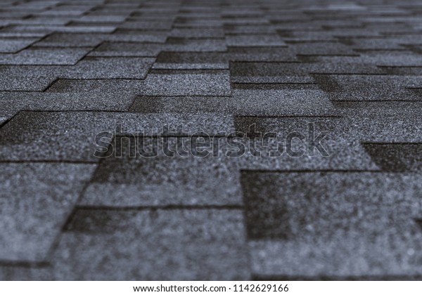 Soft roof tiled gray\
grainy texture on the top of a village house; grey soft roofing\
tiles covering a building, focus on the middle distance, shallow\
depth of field