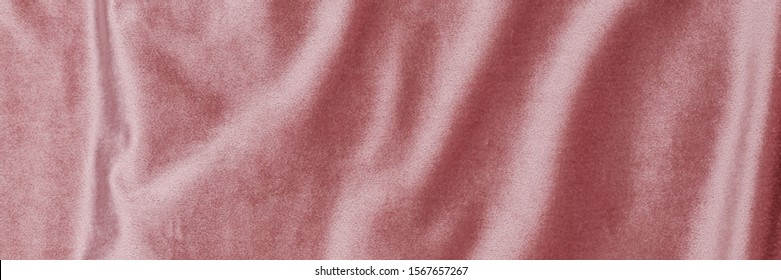 Soft rose plush fabric with drapery. Shiny draped velour background. Wrinkled luxurious cloth background. Smooth elegant pink silk velvet or satin texture,  banner