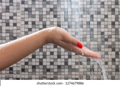 Soft selective focus of hands and droplets of water from shower with pattern background
