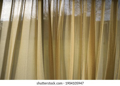 Soft, Sheer Linen Curtains Billow In A Gentle Breeze, Letting Daylight In Through The Beige Material