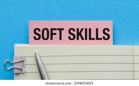 Soft Skills text concept write on pink sticker with notebook on blue background