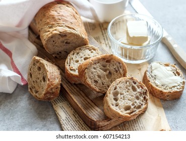 Soft slices of fragrant bread with butter on a wooden board - Shutterstock ID 607154213
