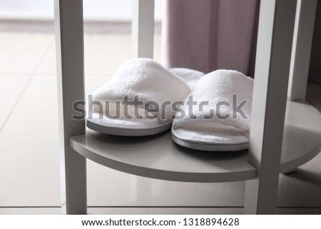 Soft slippers on shelf in room