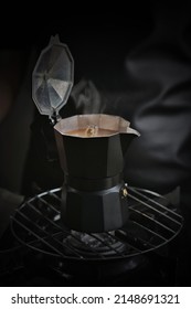 Soft Smoke And Smell Of Boiling Coffee Hover Above Small Black Brewing Pot Are Place On Stainless Steel Grate Ready To Serve For Whom Enjoy With Flavorful Coffee. Fascination With Coffee Concept.