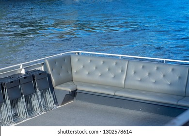 Soft sofas on board a pleasure yacht against the backdrop of water