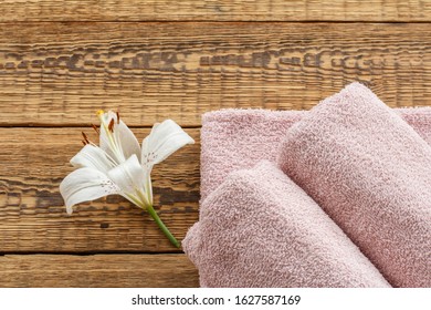 Soft Terry Towels With White Lily Flower On Old Wooden Boards. Top View.