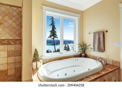 Soft Tones Bathroom Interior With Round Whirlpool Bath Tub And Scenic View From Window