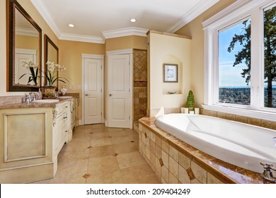 Soft Tones Bathroom Interior With Tile Floor And Tile Wall Trim, Antique Vanity With Mirror And Round Bath Tub In Luxury House