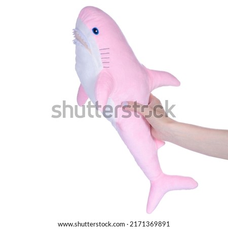 Soft toy pink shark in hand on white background isolation